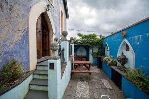un edificio azul y blanco con un banco en un patio en Salem The Blue Chapel, en Llwyngwril