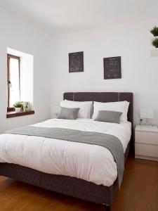 a bedroom with a large bed with white walls at ZagMé 365 in Asprangeloi