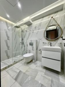 une salle de bain avec un lavabo, des toilettes et un miroir dans l'établissement TANGERSUITE FAMILY MARINA BAy, à Tanger