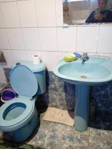 a bathroom with a blue toilet and a sink at Casa silvia in Llanquihue
