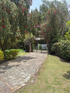 a garden with a gate and some bushes and trees at Finca Villa Patricia in Paipa
