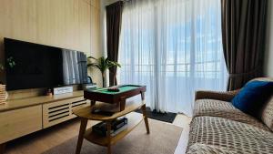 a living room with a flat screen tv and a couch at Mutiara Melaka Beach Resort Condominium,Pantai Puteri Melaka in Malacca