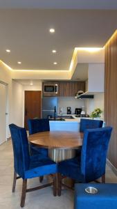 a kitchen with a wooden table and blue chairs at Espectacular y exclusivo departamento en Monterrey in Monterrey +24 photos