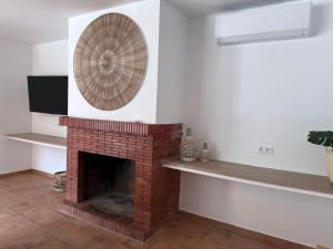 a living room with a brick fireplace with a fan at Villa Ibañez Alto in Villanueva del Arzobispo