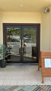 a door to a store with a man standing outside at Chikotto Inn in Kumano