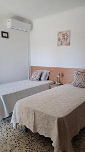 a bedroom with two beds and a couch at Vivenda Palheiras in Roncão