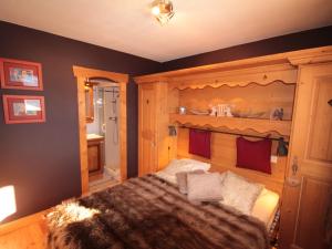a bedroom with a bed with a wooden wall at Les Saisies: 3 pièces cosy, 2 sdb, balcon, parking, 6 pers - FR-1-293-78 in Villard-sur-Doron