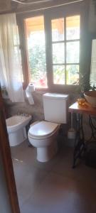 un bagno con un water, un lavandino e una finestra di lacasitadepiedraCabana a Unquillo