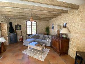 a living room with a couch and a table at Le Domaine de Camberoux La Petite Longère in Saint-Marcel-du-Périgord