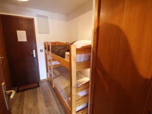 a room with two bunk beds and a door at Beau studio cabine - 4 personnes, balcon exposé sud - FR-1-293-172 in Les Saisies