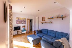 a living room with a blue couch and a tv at Beautiful and Warm 5-bed Home in Newark by Renzo, Free Parking, Close to A1 in South Muskham