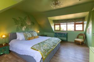 a bedroom with a large bed with green walls at Beautiful and Warm 5-bed Home in Newark by Renzo, Free Parking, Close to A1 in South Muskham