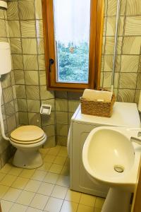 ein Badezimmer mit Toilette, Waschbecken und Fenster in der Unterkunft Artesina in Sella della Turra + 13 Fotos