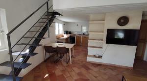 cocina con escalera y mesa con sillas en Le Barry, en Tulette 18 fotos más