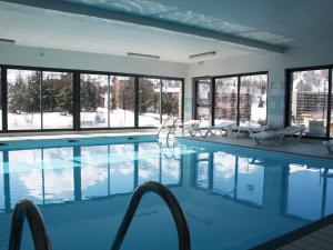 a large swimming pool with chairs and windows at Charmante Résidence avec Piscine Chauffée à 300m des Pistes - 4 Pièces pour 8 Personnes à Superdevoluy - FR-1-504-431 in Superdevoluy
