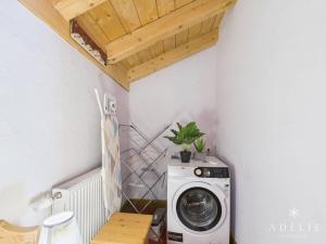 een wasruimte met een wasmachine en een houten plafond bij Chalet 4 pièces centre station, parking inclus - FR-1-398-591 in La Rosière