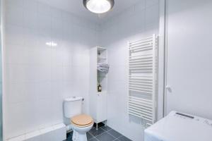 ein weißes Badezimmer mit Toilette und Waschbecken in der Unterkunft La Pause Urbaine - Proximité Lyon - Terrasse Privée in Vaulx-en-Velin + 8 Fotos