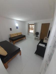 a living room with two beds and a desk at Casa com saída p/ praia do Peró Cabo Frio in Peró