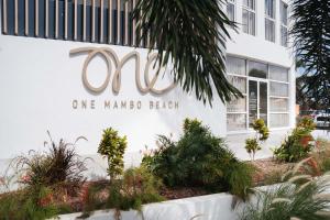 a sign on the side of a one mana beach building at ONE Mambo Beach Residences by Bocobay Curaçao in Willemstad