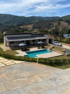 an aerial view of a house with a swimming pool at Chalés Varandas da Serra in Monte Verde