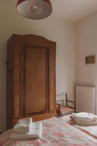 a bedroom with a large wooden cabinet next to a bed at Humus Sapiens 1 in Tavarone
