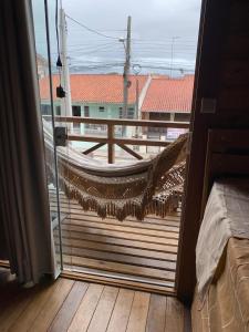- un balcon avec un hamac sur une terrasse en bois dans l'établissement Canto Gira Sol - Estúdio Borboleta, à Penha
