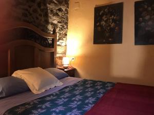 a bedroom with a bed with a blue and white blanket at La Plazuela - Navalguijo in Navalguijo