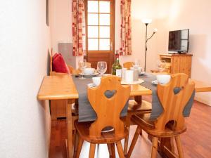a dining room with a table and chairs with wine glasses at Charmant 2 Pièces pour 6 Personnes avec Piscine et Terrasse - Proche Saint-Lary-Soulan - FR-1-504-140 in Vignec