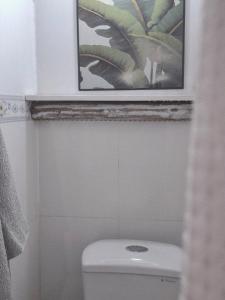 a bathroom with a toilet with a picture above it at Tiny house, traditional, friendly neighbour, center, sunset lake view in Can Tho