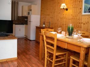 a kitchen with a wooden table with chairs and a refrigerator at Chalet Mitoyen Duplex 3 Pièces - 6 Pers., Résidence Le Hameau du Puy, Superdevoluy - FR-1-504-447 in Superdevoluy