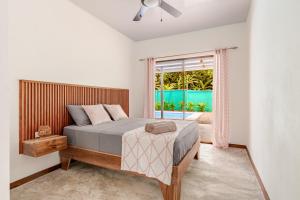 a bedroom with a bed and a window at Villa Oropendola a 5 minutos de cahuita in Comadre
