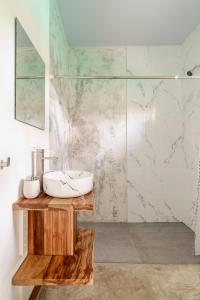 a bathroom with a sink and a shower at Villa Oropendola a 5 minutos de cahuita in Comadre +20 photos