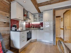 a kitchen with white cabinets and a brick wall at Appartement rénové 1 chambre + alcôve, ski aux pieds, Val Village - FR-1-567-65 in Val dʼIsère