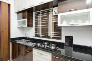 a kitchen with a black counter top and a sink at Reunion Aaradhya Villa in Udupi