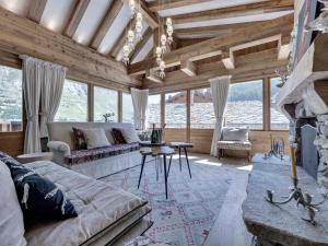 Una sala de estar con un sofá y una chimenea. en Chalet skis aux pieds avec piscine et sauna à Val-d'Isère - FR-1-567-126, en Val dʼIsère