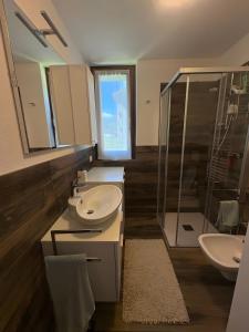 a bathroom with two sinks and a shower at Residenza Viola in Valdidentro +13 photos