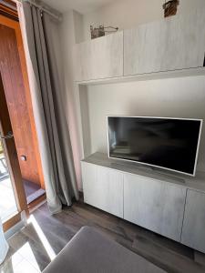 a living room with a large television on a wall at Residenza Viola in Valdidentro