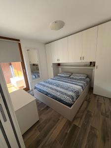 a bedroom with a bed and white cabinets at Residenza Viola in Valdidentro