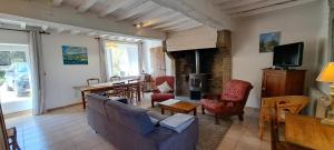a living room with a couch and chairs and a table at Maison De Caractère Bord De Mer in Gouberville