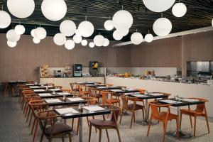 a dining room with tables and chairs and lights at Metropol Design Hotel Old Town in Prague