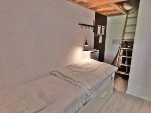 - une petite chambre avec un lit et une échelle dans l'établissement Superbe Studio Mezzanine Rénové au Cœur du Grand Bornand – 4 Couchages, Balcon, Proche Commerces et Ski - FR-1-458-162, au Grand-Bornand