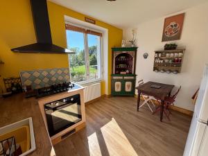 una cucina con piano cottura, tavolo e finestra di Chez Patricia a Graçay