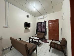 un salon avec un canapé, des chaises et une télévision dans l'établissement CSG Homestay Kota Marudu, à Kampong Sorosob 9 autres photos