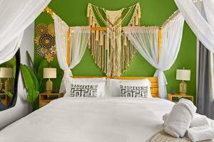 a bedroom with a white bed with a green wall at Lookout Luxe 2BR | Shuffleboard | Classy | 1GB in Dallas