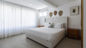 Un dormitorio blanco con una cama grande y una ventana. en Apartamento dos habitaciones rdm 6101, en Sampiño