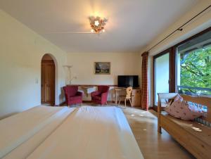 a bedroom with a bed and a table and chairs at Hotel Forsthaus Oberau in Oberau