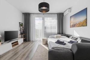 a bedroom with a bed and a couch and a tv at Bratislava Airport Apartment in M R Stefanik