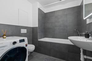 a bathroom with a toilet and a sink and a washing machine at Bratislava Airport Apartment in M R Stefanik +16 photos