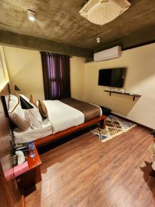 Un dormitorio con una cama y un televisor de pantalla plana. en Hunza Hard Rock Resort, en Baltit