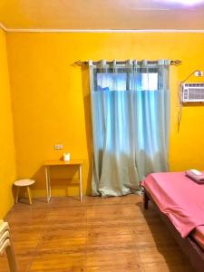 Habitación con cama y ventana con mesa. en Three Sister's Inn, en Siquijor 1 foto más